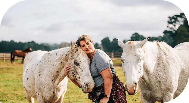 A woman resting her forehead gently against a rescued horse